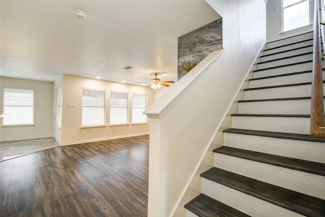 staircase with wood-type flooring and ceiling fan