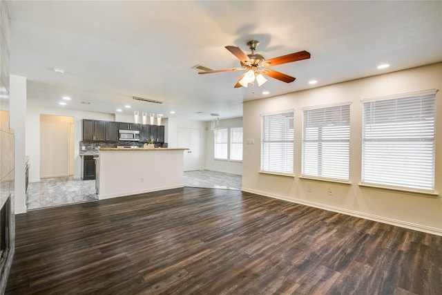 unfurnished living room featuring dark hardwood / wood-style flooring and ceiling fan