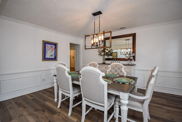 dining area with a chandelier, crown molding, dark wood-type flooring, and a textured ceiling