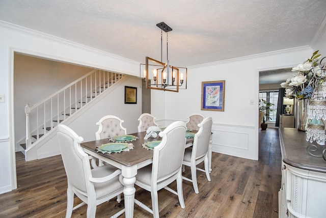 dining room featuring dark hardwood / wood-style floors, ornamental molding, a textured ceiling, and a chandelier