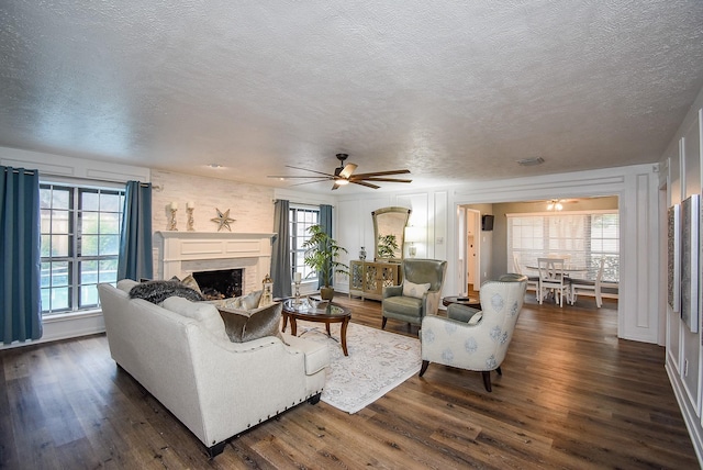 living room with dark hardwood / wood-style floors, a fireplace, and a wealth of natural light