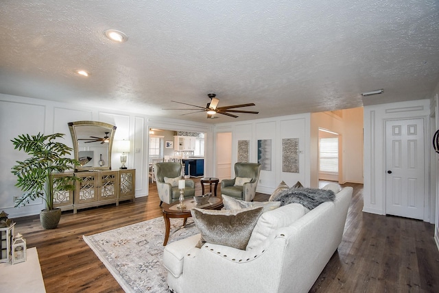 living room with a textured ceiling and dark hardwood / wood-style floors