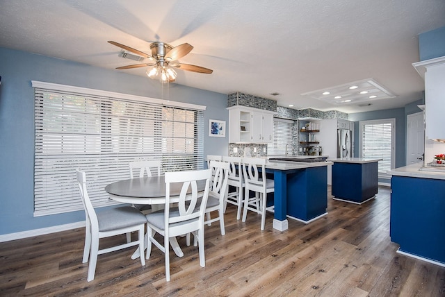 dining space featuring dark hardwood / wood-style floors, ceiling fan, and a textured ceiling