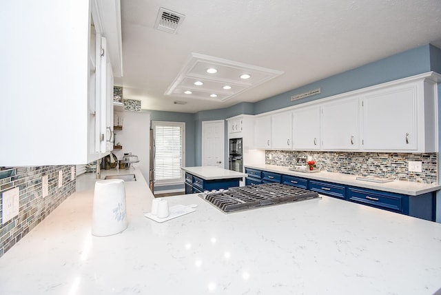 kitchen featuring blue cabinetry, sink, backsplash, white cabinets, and black appliances