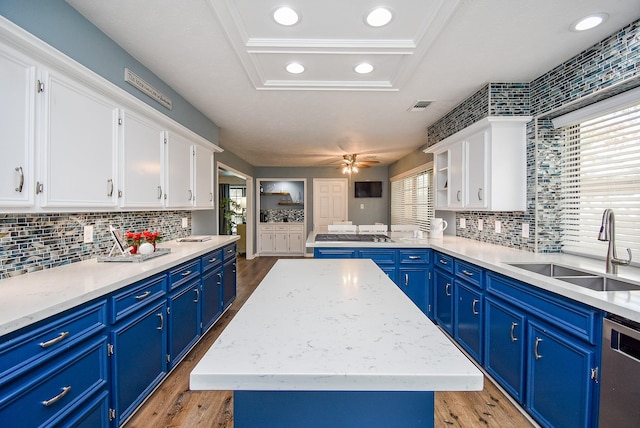 kitchen with plenty of natural light, a center island, blue cabinets, and sink