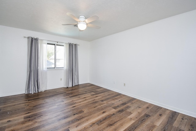 empty room with a textured ceiling, ceiling fan, and dark wood-type flooring