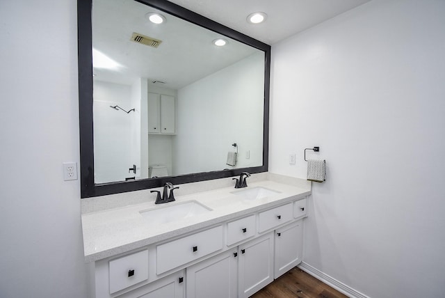 bathroom featuring vanity, hardwood / wood-style flooring, and toilet