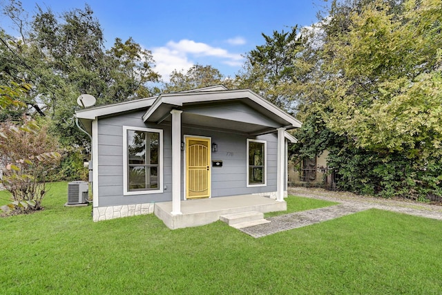 bungalow-style house with a front lawn, covered porch, and central AC unit