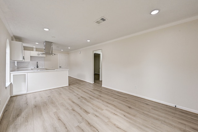 unfurnished living room featuring crown molding and light hardwood / wood-style flooring