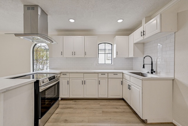 kitchen with white cabinets, island range hood, light hardwood / wood-style flooring, and stainless steel range with electric cooktop