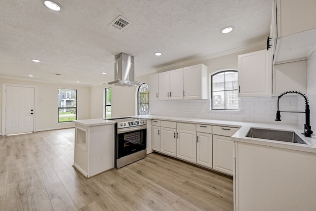 kitchen with island exhaust hood, kitchen peninsula, stainless steel electric stove, sink, and white cabinetry