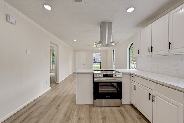 kitchen featuring electric range, island exhaust hood, kitchen peninsula, white cabinets, and light wood-type flooring