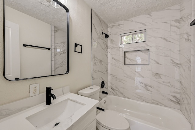 full bathroom featuring toilet, vanity, a textured ceiling, and tiled shower / bath