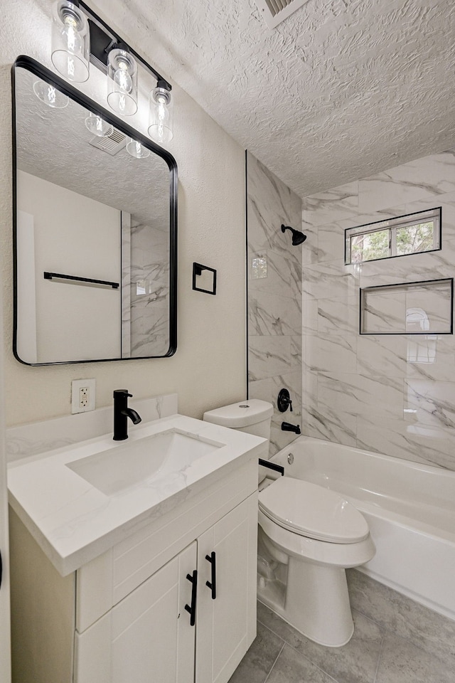 full bathroom with tiled shower / bath combo, tile patterned flooring, a textured ceiling, toilet, and vanity