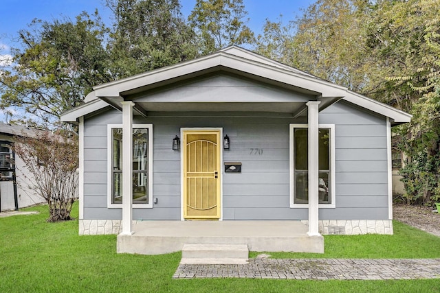 bungalow-style home with a porch and a front lawn