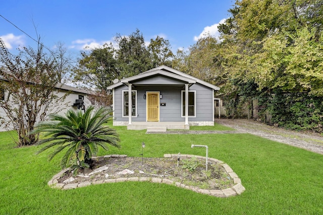 bungalow-style home featuring covered porch and a front yard