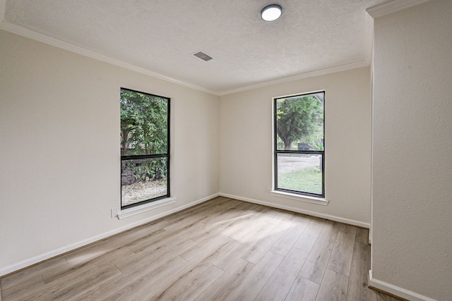 spare room featuring ornamental molding, a textured ceiling, and light hardwood / wood-style flooring