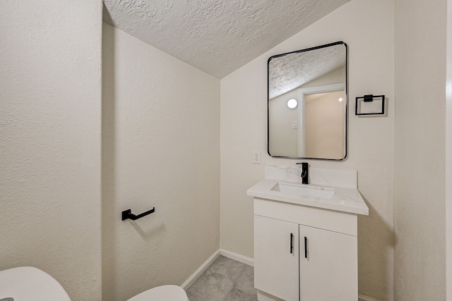 bathroom featuring vanity, lofted ceiling, tile patterned floors, toilet, and a textured ceiling