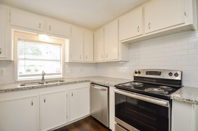 kitchen featuring white cabinets, appliances with stainless steel finishes, light stone counters, and sink