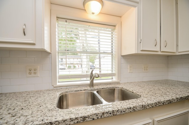 kitchen with white cabinets, decorative backsplash, a healthy amount of sunlight, and sink