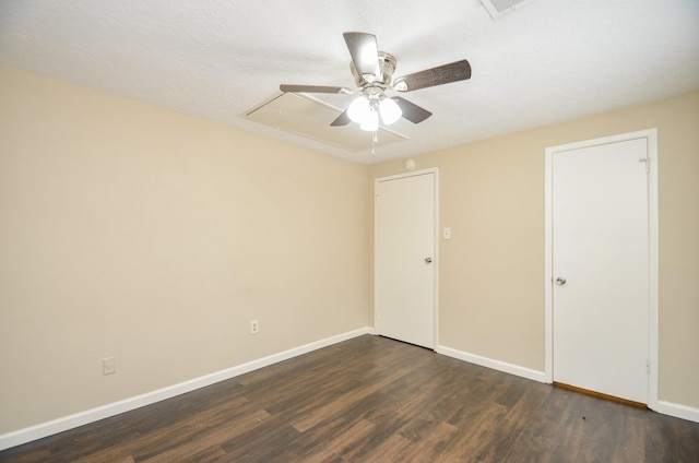 empty room with a textured ceiling and dark hardwood / wood-style flooring