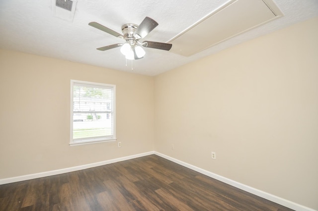 spare room with a textured ceiling, ceiling fan, and dark wood-type flooring