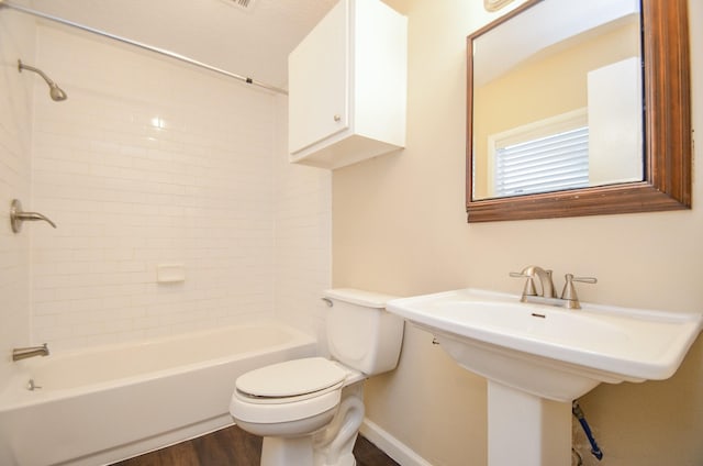 full bathroom featuring wood-type flooring, toilet, tiled shower / bath, and sink