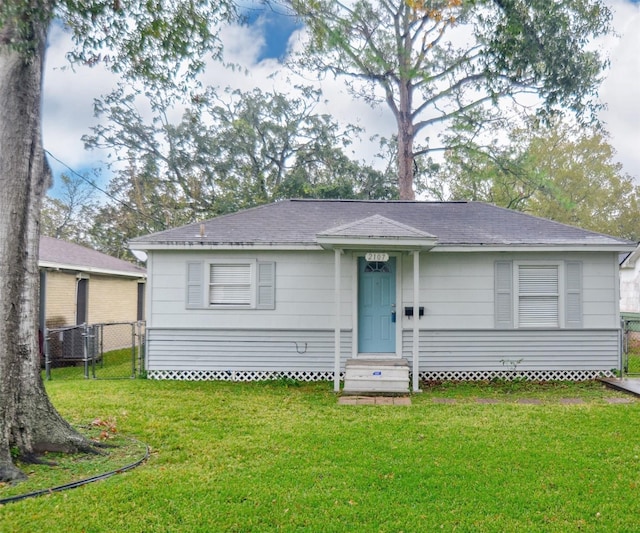 view of front of home with a front yard and central air condition unit