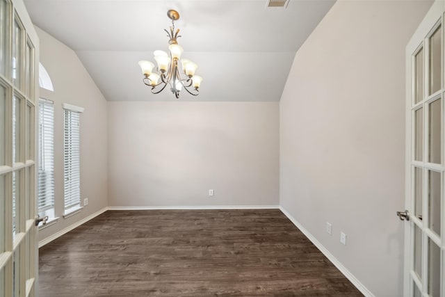 unfurnished room with lofted ceiling, dark wood-type flooring, and a notable chandelier