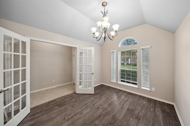 unfurnished dining area featuring dark hardwood / wood-style floors, french doors, a chandelier, and vaulted ceiling