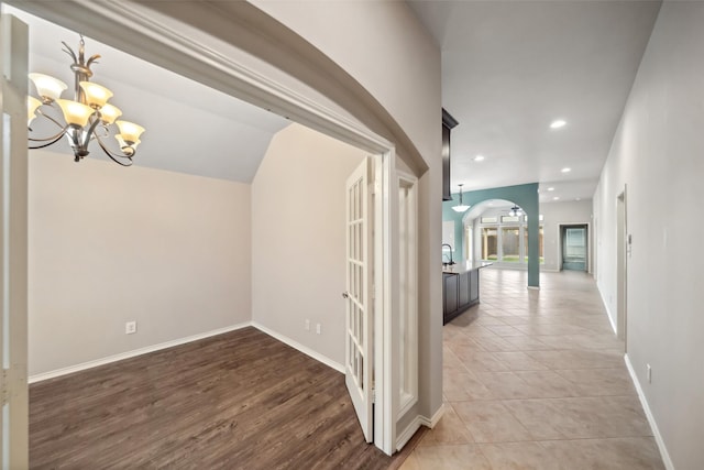 hallway featuring sink, a chandelier, vaulted ceiling, and hardwood / wood-style flooring