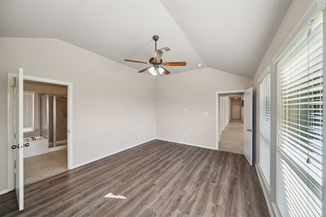 unfurnished bedroom featuring connected bathroom, ceiling fan, dark wood-type flooring, and lofted ceiling