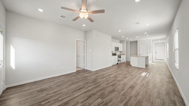 unfurnished living room featuring wood-type flooring and ceiling fan