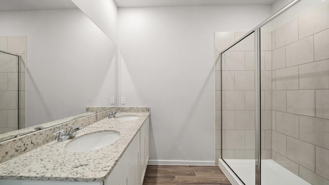 bathroom with walk in shower, wood-type flooring, and vanity