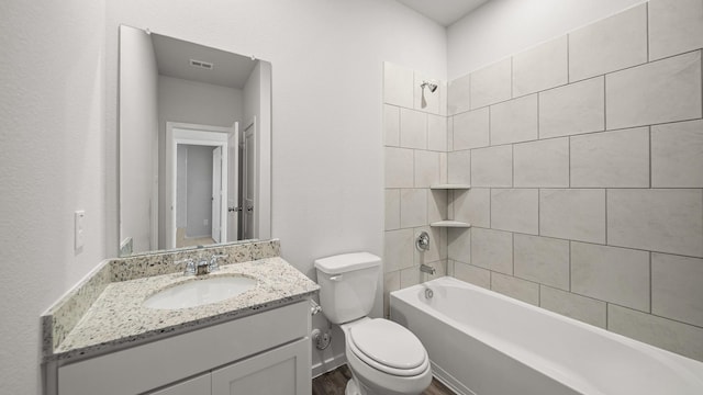 full bathroom with vanity, tiled shower / bath, and toilet