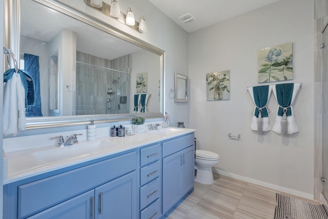 bathroom featuring vanity, a shower with shower door, and toilet