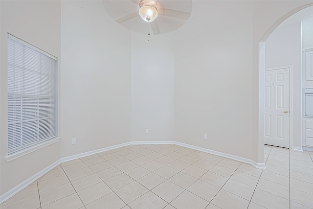 tiled spare room with ceiling fan