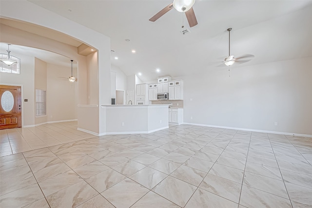 unfurnished living room featuring light tile patterned floors, high vaulted ceiling, and ceiling fan