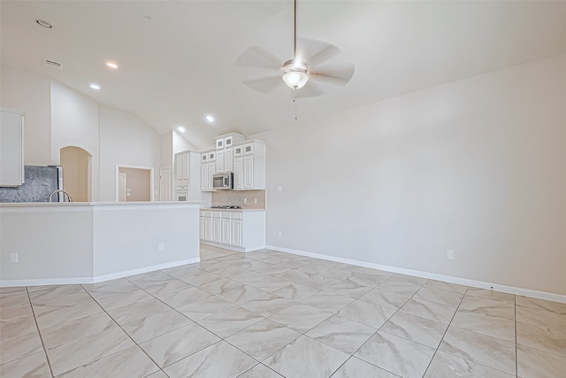 unfurnished living room featuring ceiling fan and lofted ceiling