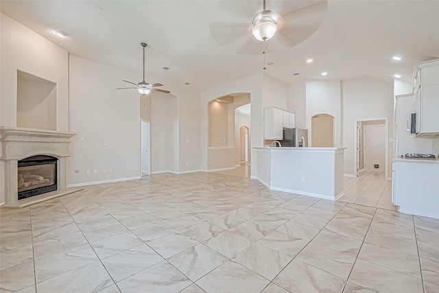 unfurnished living room featuring ceiling fan and vaulted ceiling