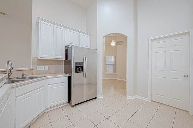 kitchen featuring white cabinetry, sink, ceiling fan, stainless steel fridge with ice dispenser, and light tile patterned floors