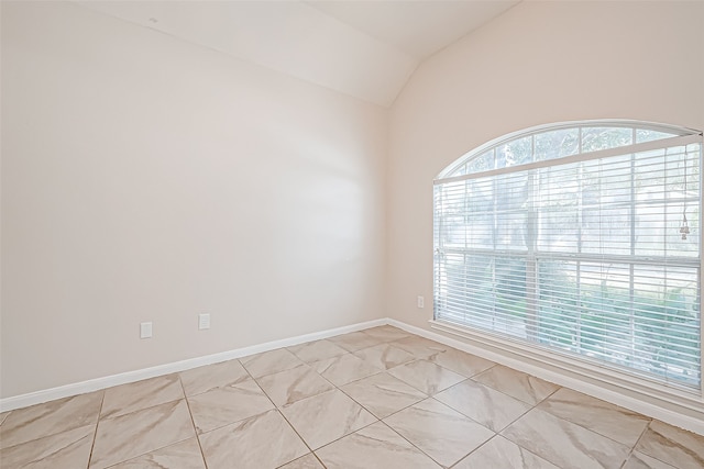 empty room featuring light tile patterned floors and lofted ceiling