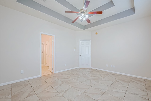 unfurnished room with a raised ceiling and ceiling fan