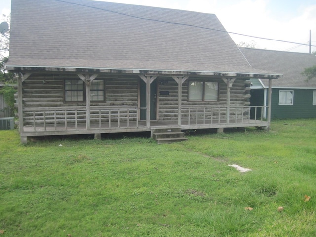 rear view of house with covered porch, a yard, and central air condition unit