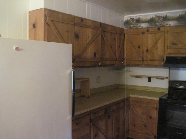 kitchen featuring ventilation hood, white fridge, and black electric range oven