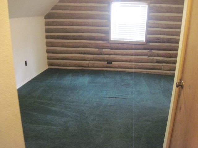 empty room with carpet, vaulted ceiling, and log walls