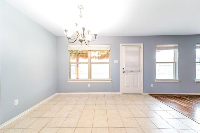 unfurnished room featuring light hardwood / wood-style floors and a notable chandelier