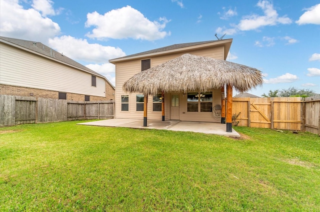 rear view of property featuring a lawn and a patio area