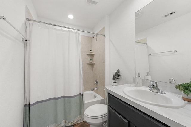 full bathroom featuring toilet, shower / bath combo with shower curtain, and vanity