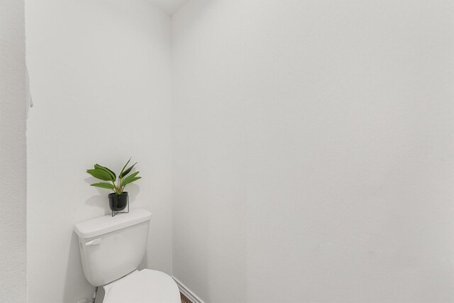 bathroom with baseboards and toilet